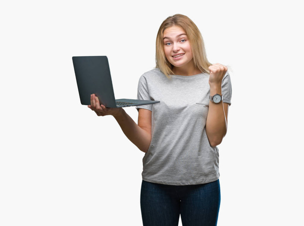 Mulher caucasiana jovem usando laptop computador sobre fundo isolado gritando orgulhoso e celebrando vitória e sucesso muito animado, torcendo emoção
 - Foto, Imagem