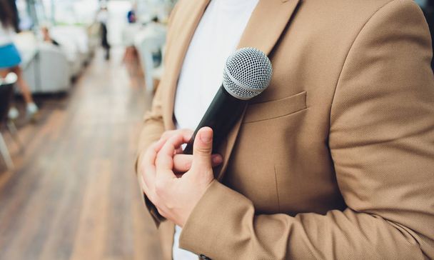 blurred of businessman hand holding microphone for speech presentation in conference hall, Seminar and Speaker Concept. vintage tone. - Fotoğraf, Görsel
