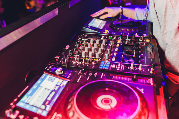 DJ RAS op het podium van de nachtclub. achtergrond van de mensen dansen. - Foto, afbeelding
