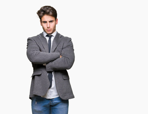 Молодой бизнесмен в костюме и галстуке на изолированном фоне скептически и нервно, неодобряющее выражение лица со скрещенными руками. Отрицательное лицо
. - Фото, изображение