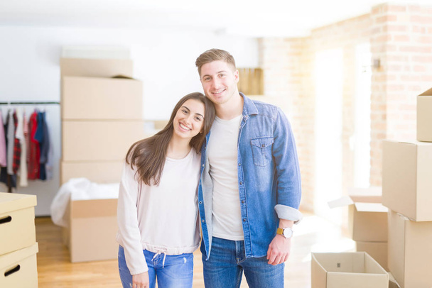 Όμορφο νεαρό ζευγάρι που κινείται σε ένα νέο σπίτι, στέκεται στο νέο APA - Φωτογραφία, εικόνα