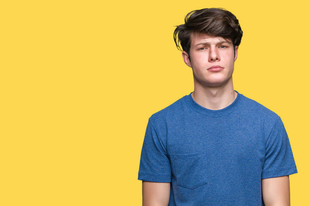 Νεαρός όμορφος άνδρας φορώντας μπλε t-shirt πάνω από το απομονωμένο φόντο σκεπτικιστής και νευρικό, συνοφρυωμένος αναστατωμένος εξαιτίας προβλήματος. Αρνητικό πρόσωπο. - Φωτογραφία, εικόνα