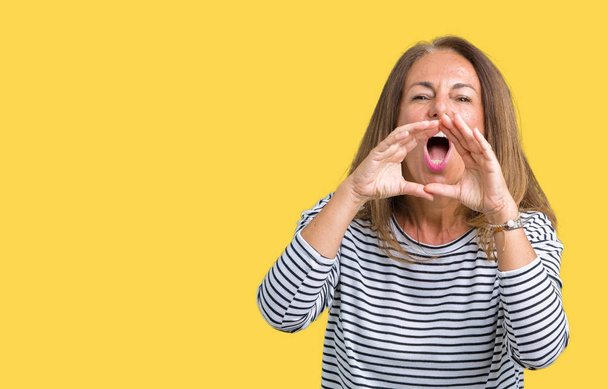 Красивая женщина средних лет в полосах свитер на изолированном фоне кричать сердито, с руками над ртом
 - Фото, изображение