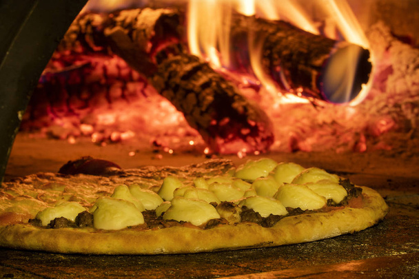 Italian pizza inside a wood oven  - Photo, Image