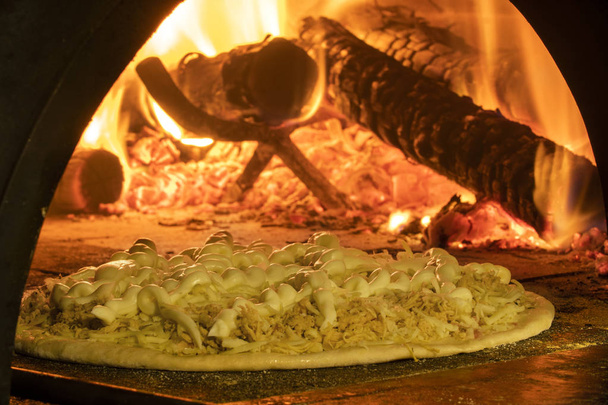 Italian pizza inside a wood oven  - Foto, afbeelding