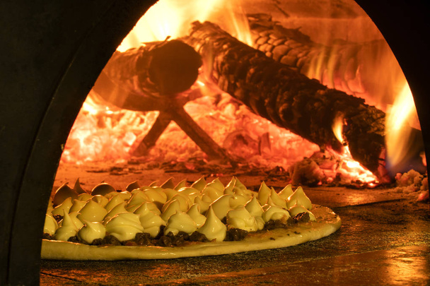 Italian pizza inside a wood oven  - Фото, изображение