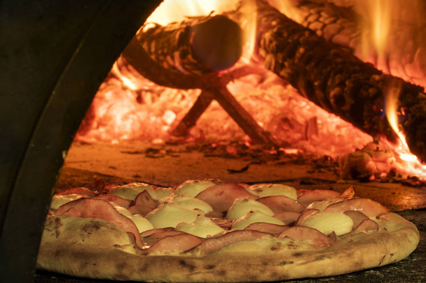 Italian pizza inside a wood oven  - Fotó, kép