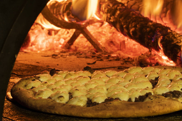 Italian pizza inside a wood oven  - Valokuva, kuva