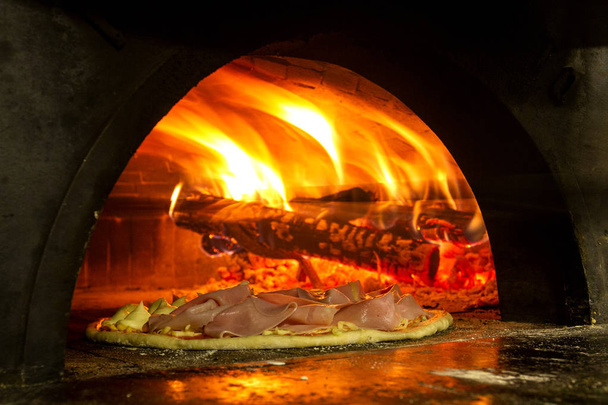 Italian pizza inside a wood oven  - Foto, imagen