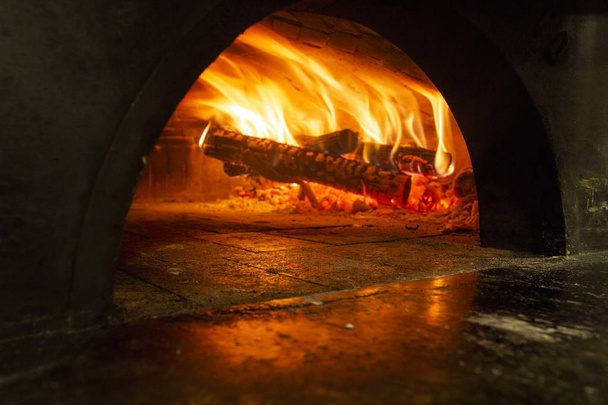 Image of a brick pizza oven with fire - Photo, image