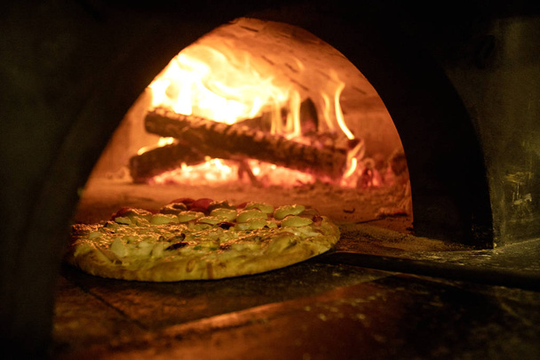 Italian pizza inside a wood oven  - Foto, immagini
