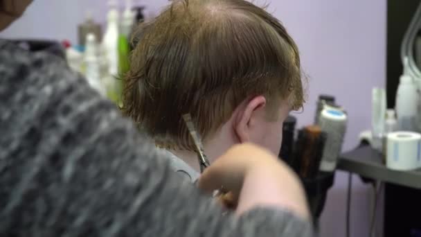 Genç bir adam berber dükkanında saç keser. Yakın çekim - Video, Çekim