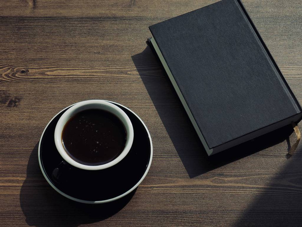 Дерев'яний фон дошки з кавою та чорними книгами
 - Фото, зображення