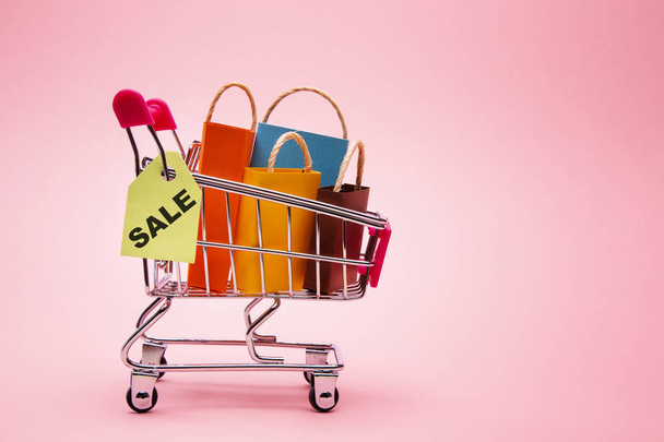 Gifts in shopping cart on rose background - Valokuva, kuva