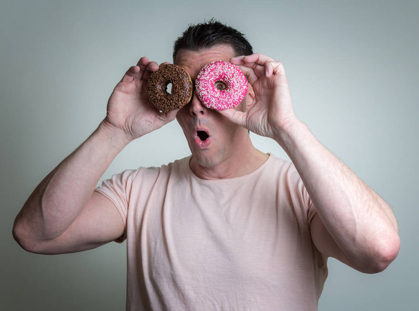 Homem caucasiano com donuts
 - Foto, Imagem