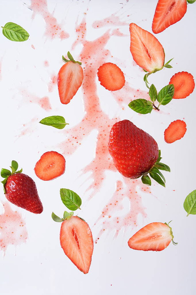 Flying fresh strawberries with mint leaves. Food levitation concept. Creative food layout. - Fotó, kép