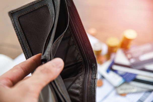 tenant un portefeuille vide en main et pièce, facture, carte de crédit
 - Photo, image