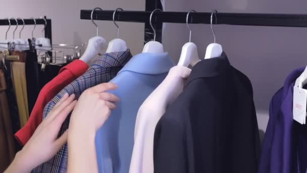 γυναικεία χέρια ταξινομήσετε φορέματα σε ράφια στο κατάστημα κοντινή θέα - Πλάνα, βίντεο