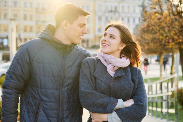 Outdoor portrait of happy embracing couple, handsome man and woman walking, background evening city - Valokuva, kuva