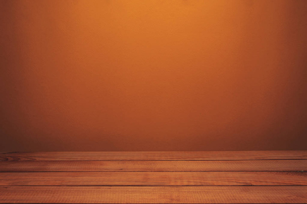 Όμορφο κόκκινο ξύλινο τραπέζι και πορτοκαλί τοίχο φόντο. - Φωτογραφία, εικόνα