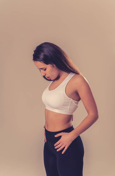 Beauty portrait of sport confident young woman wearing gym top looking sensual and fit. Studio shot of cheerful latin strong woman in sportswear looking healthy and sexy. In fitness Body care concept. - Фото, зображення