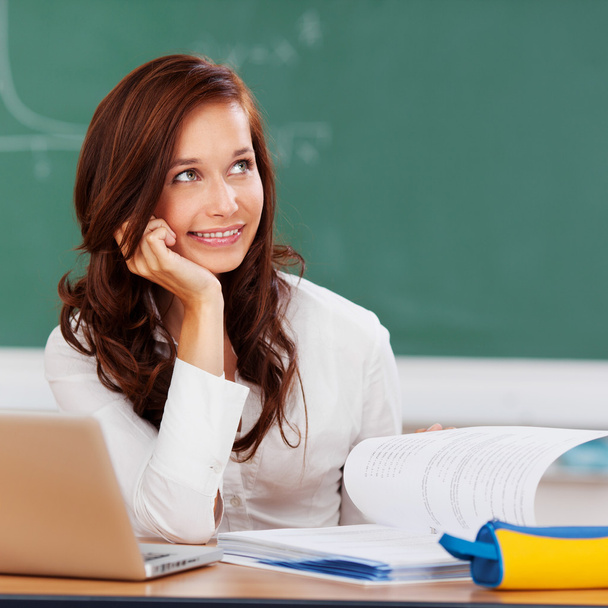Attractive female student thinking as she studies - Photo, image