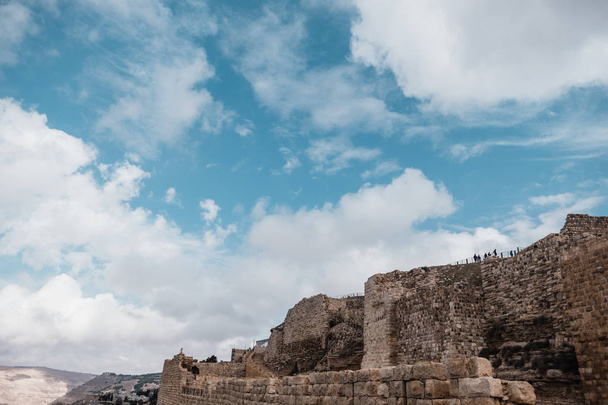 Oude stenen muren in het landschap van de woestijn tegen blauwe bewolkte hemel van Jordanië, Azië - Foto, afbeelding