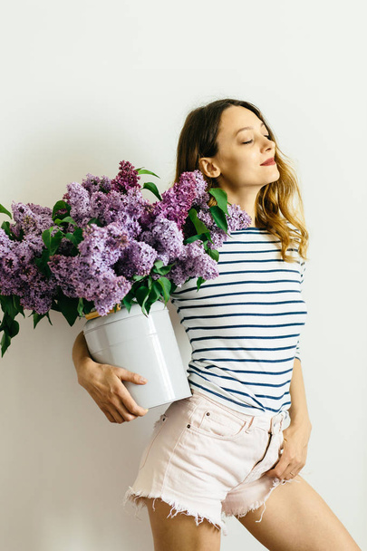Girl with a bouquet of lilac on a white background - Photo, Image