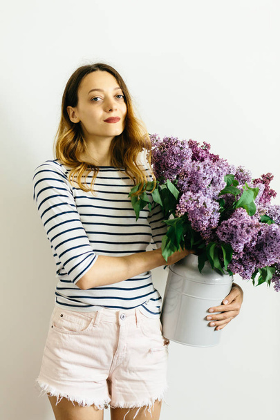 Girl with a bouquet of lilac on a white background - 写真・画像