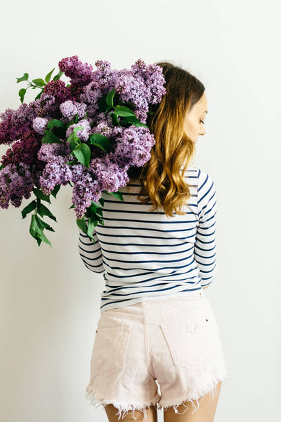 Dívka stojící vzadu s kyticí fialovou na bílém pozadí - Fotografie, Obrázek