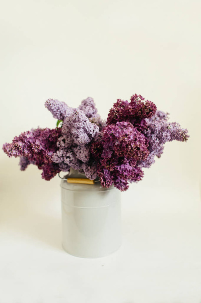 Buquê roxo de flores lilás em um vaso elegante em um fundo branco
 - Foto, Imagem
