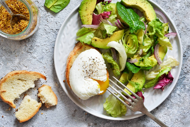 Fresh salad with spinach, avocado, egg plow and sauce on a concr - Foto, imagen