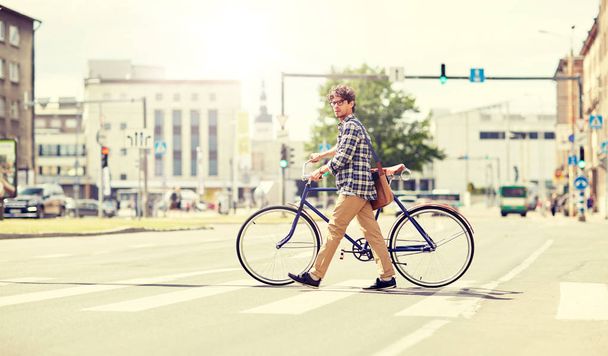 young man with fixed gear bicycle on crosswalk - Foto, imagen