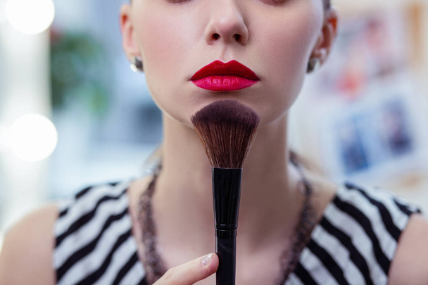 Close up of a makeup brush touching the chin - Фото, изображение