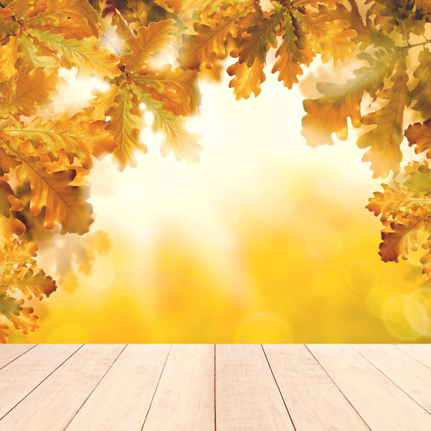 Fondo amarillo otoño con mesa de madera vacía blanca
 - Foto, imagen
