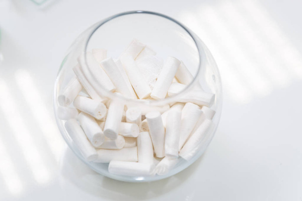 Täysi lasiastia steriilillä puuvillapyyhkeillä hammaslääkärin hammaspöydällä
 - Valokuva, kuva