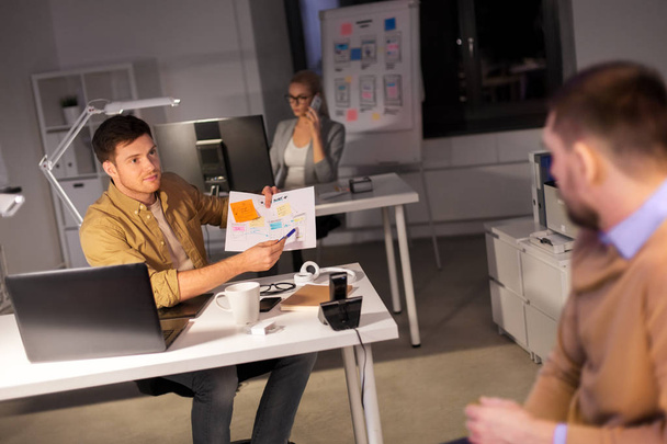 бизнес-команда с бумагами, работающими поздно в офисе
 - Фото, изображение
