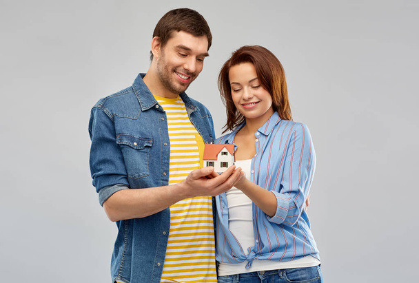 smiling couple holding house model - Foto, Imagen
