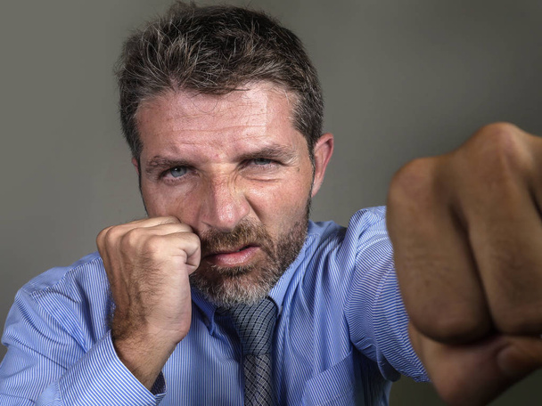 dramatic portrait of middle aged upset and fierce man boxing throwing punch looking furious suffering work stress fighting for business - Фото, зображення
