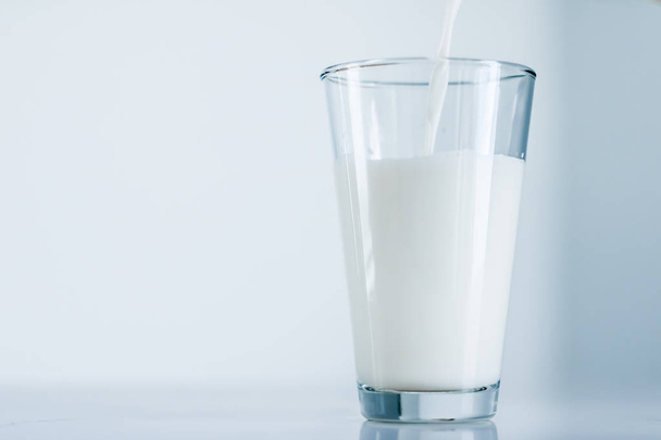 Światowy dzień mleka, wylewając się do szklanki na marmurowym stole - Zdjęcie, obraz