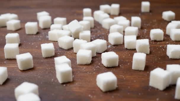 Кубики белого сахара на гладкой коричневой поверхности
 - Кадры, видео