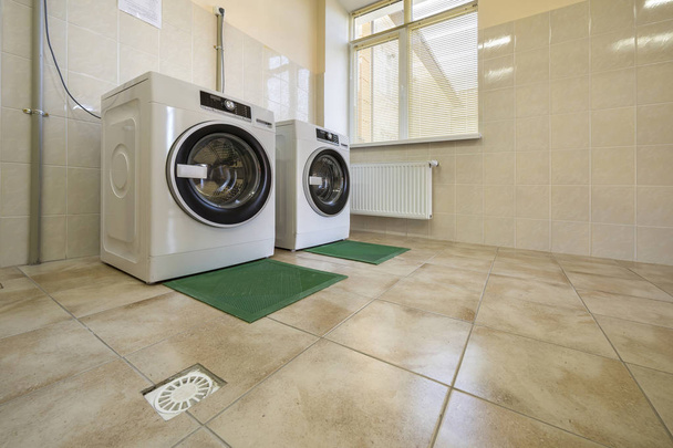 Modernas lavadoras industriales nuevas en baño de azulejos limpios o
 - Foto, Imagen