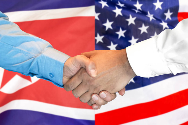 Handshake op Noord-Korea en USA vlag achtergrond. - Foto, afbeelding
