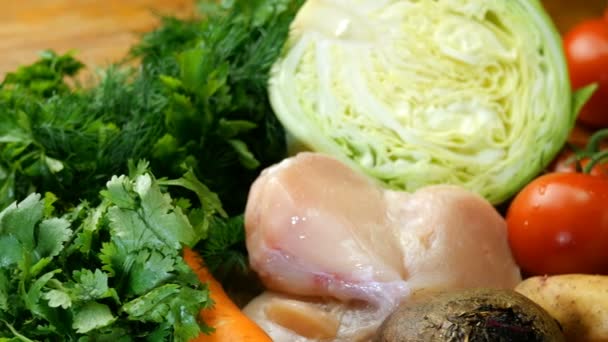 Διάφορα ωμά λαχανικά και ωμό κρέας κοτόπουλου για να κάνετε σούπα, Μπορς ή ένα υγιεινό γεύμα. Όπως και ο άνηθος, ο μαϊντανό και άλλα γαστρονομικά βότανα. Έννοια της υγιεινής διατροφής. Επιλεκτική εστίαση. - Πλάνα, βίντεο