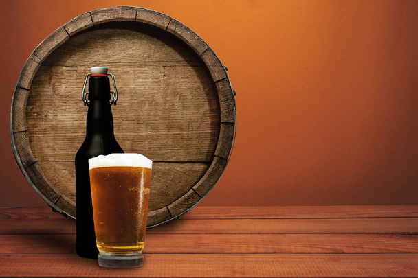 Canna di legno, bicchiere di birra e bottiglia nera su un tavolo di legno rosso. Bellissimo sfondo arancione
. - Foto, immagini