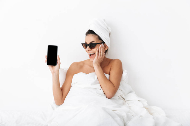 Image of excited woman 30s wearing sunglasses wrapped in blanket - Foto, imagen
