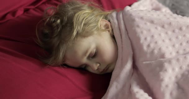 Sevimli bebek evde yatakta uyuyor. Küçük kız sabah ışığında uyku - Video, Çekim