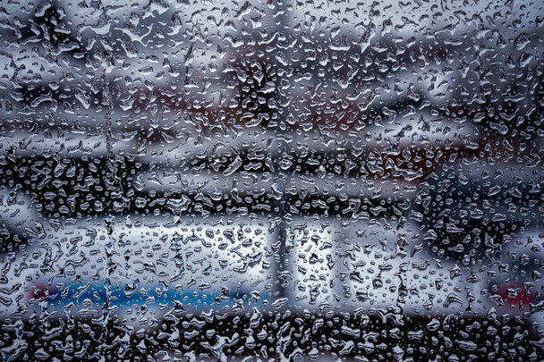 Капли дождя на оконной стеклянной поверхности с облачным фоном
 - Фото, изображение