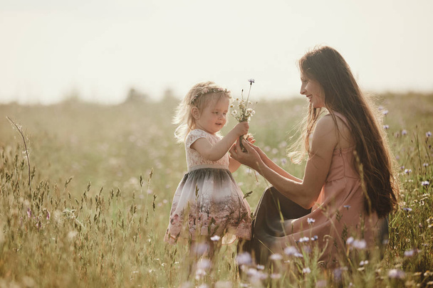 Beautiful Mother And her little daughter outdoors. Nature. Outdoor Portrait of happy family. Beauty Mum and her Child playing in Park together. Happy Mother's Day Joy. Mom and Baby - Fotoğraf, Görsel