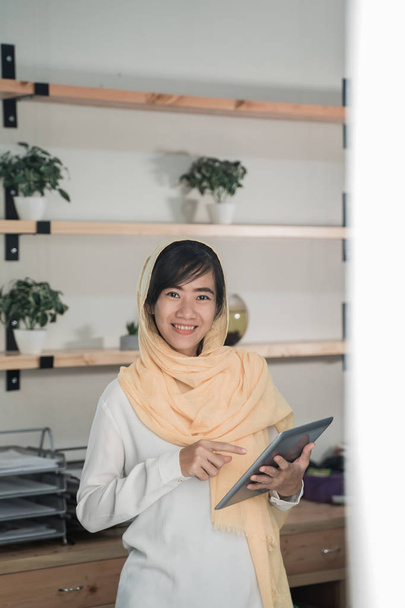 muslim woman wearing hijab using tablet pc - Фото, изображение